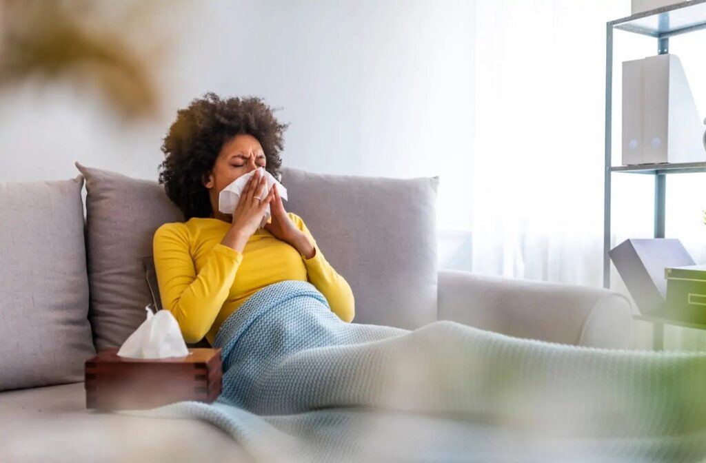 Woman experiencing signs of poor indoor air quality at home in Alberta